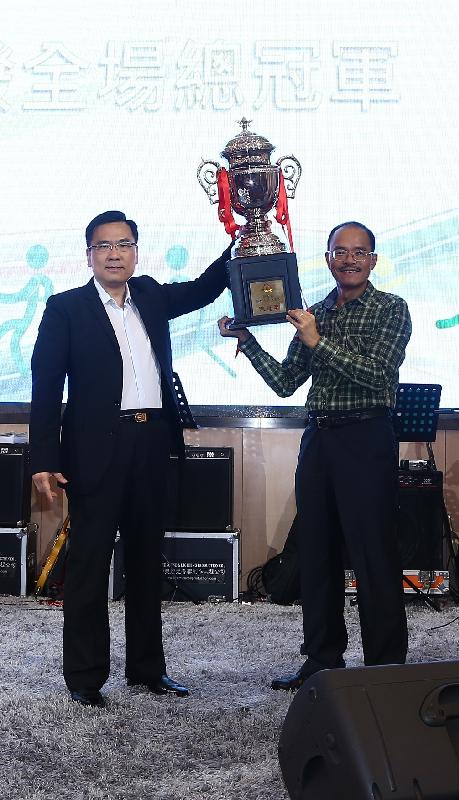 Mr Sin (left) presents the overall champion's trophy to the representative of Hong Kong Correctional Services Department, Deputy Commissioner, Mr Yau Chi-chiu.