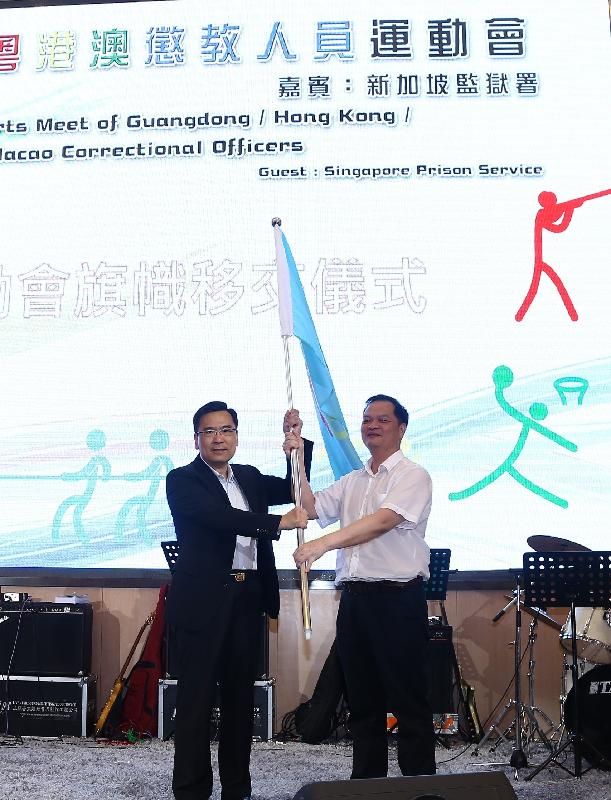 Mr Sin (left) hands over the flag of the Sports Meet to the representative of the next hosting organisation, Guangdong Provincial Prisons Administration Bureau.