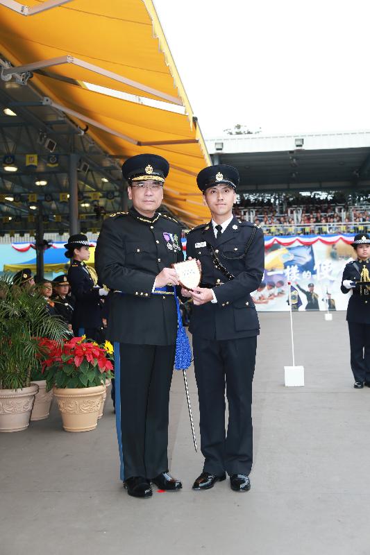 Mr Sin (left) presents the Best Recruit Award, the Principal's Shield, to Officer Mr Lam Mau at the passing-out parade.