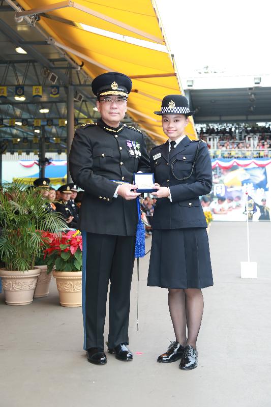 Mr Sin (left) presents the Best Recruit Award, the Golden Whistle, to Assistant Officer II Ms Chong Wing-yan at the passing-out parade.