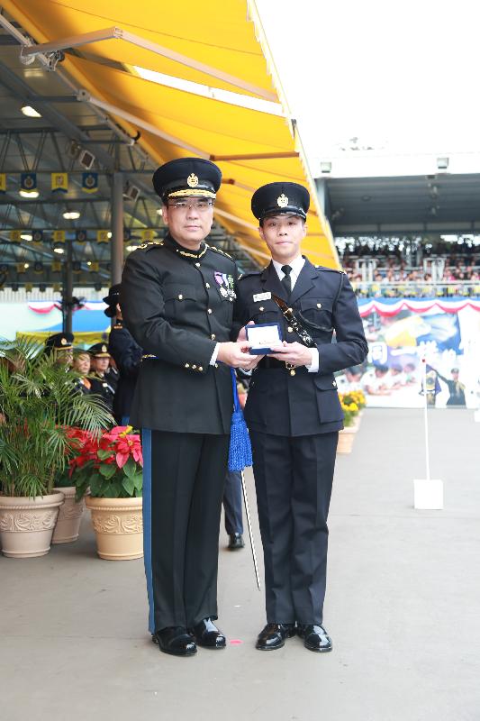 Mr Sin (left) presents the Best Recruit Award, the Golden Whistle, to Assistant Officer II Mr Cheung Ka-wai at the passing-out parade.
