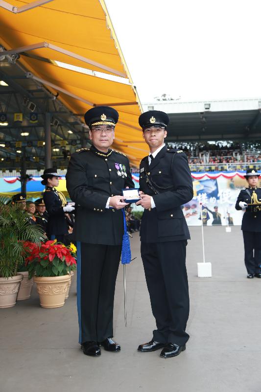 Mr Sin (left) presents the Best Recruit Award, the Golden Whistle, to Assistant Officer II Mr Poon Wing-shun at the passing-out parade.