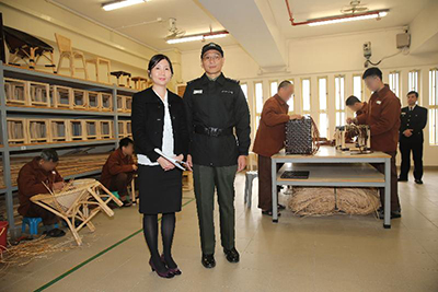 青山醫院法醫精神科部門主管蕭慧敏醫生（左）於木工及藤器工場，講解在囚人士常見的精神病和治療方法。旁為小欖精神病治療中心高級監督謝國耀（右）。