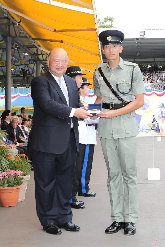 The Chief Justice of the Court of Final Appeal, Mr Geoffrey Ma Tao-li (left), presents a Best Recruit Award, the Golden Whistle, to Assistant Officer II Yeung Sze-wai at the Correctional Services Department (CSD) passing-out parade at the CSD's Staff Training Institute in Stanley today (June 17).