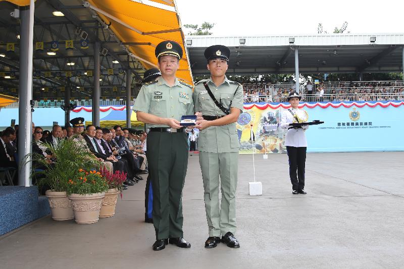The Deputy Commander of the Chinese People's Liberation Army Hong Kong Garrison, Major General Liao Zhengrong (left), presents a Best Recruit Award, the Golden Whistle, to Assistant Officer II Mr Hon Ka-hing while attending the Correctional Services Department (CSD) passing-out parade at the Staff Training Institute of the CSD in Stanley today (October 7).
