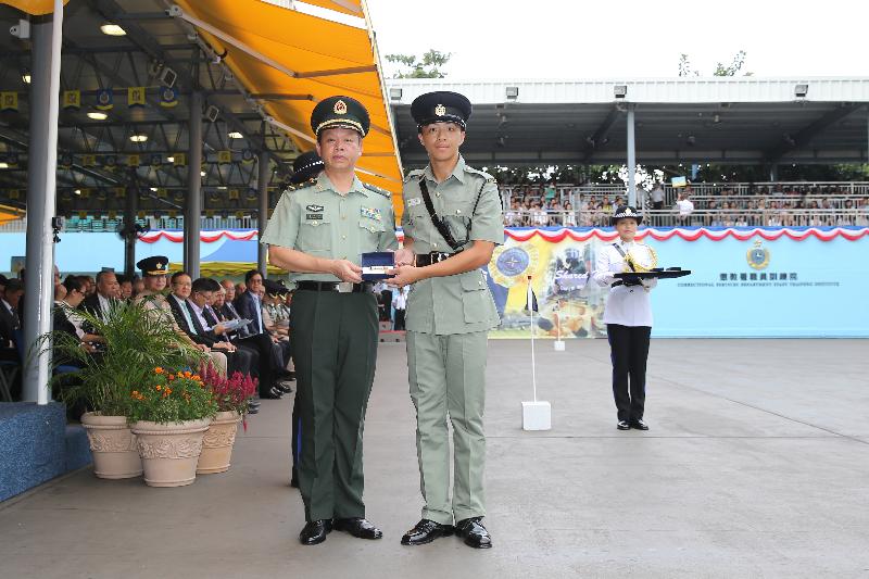 The Deputy Commander of the Chinese People's Liberation Army Hong Kong Garrison, Major General Liao Zhengrong (left), presents a Best Recruit Award, the Golden Whistle, to Assistant Officer II Mr Li Nam while attending the Correctional Services Department (CSD) passing-out parade at the Staff Training Institute of the CSD in Stanley today (October 7).