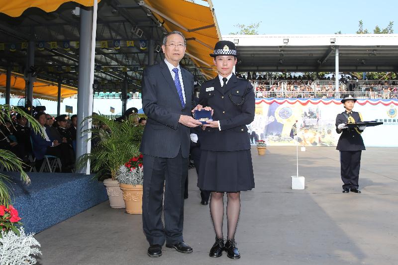 The Secretary for Security, Mr Lai Tung-kwok (left), presents a Best Recruit Award, the Golden Whistle, to Assistant Officer II Miss Leung Wing-sze at the Correctional Services Department passing-out parade at its Staff Training Institute in Stanley today (April 28).