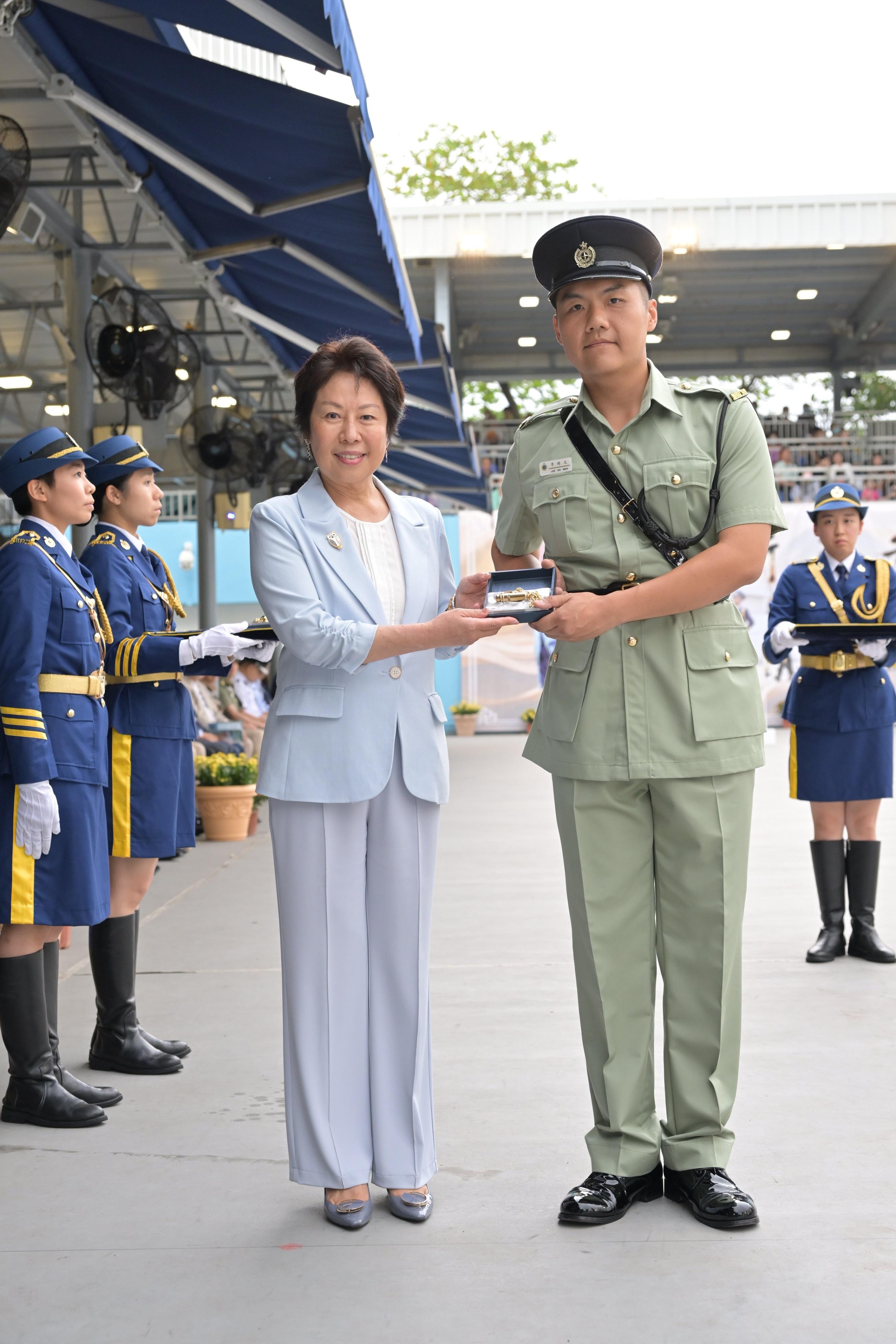 The Correctional Services Department held a passing-out parade at the Hong Kong Correctional Services Academy today (April 21). Photo shows the Chairman of the Committee on Community Support for Rehabilitated Offenders, Ms Tsui Li (left), presenting a Best Recruit Award, the Golden Whistle, to Assistant Officer II Mr Lee Ho-man.