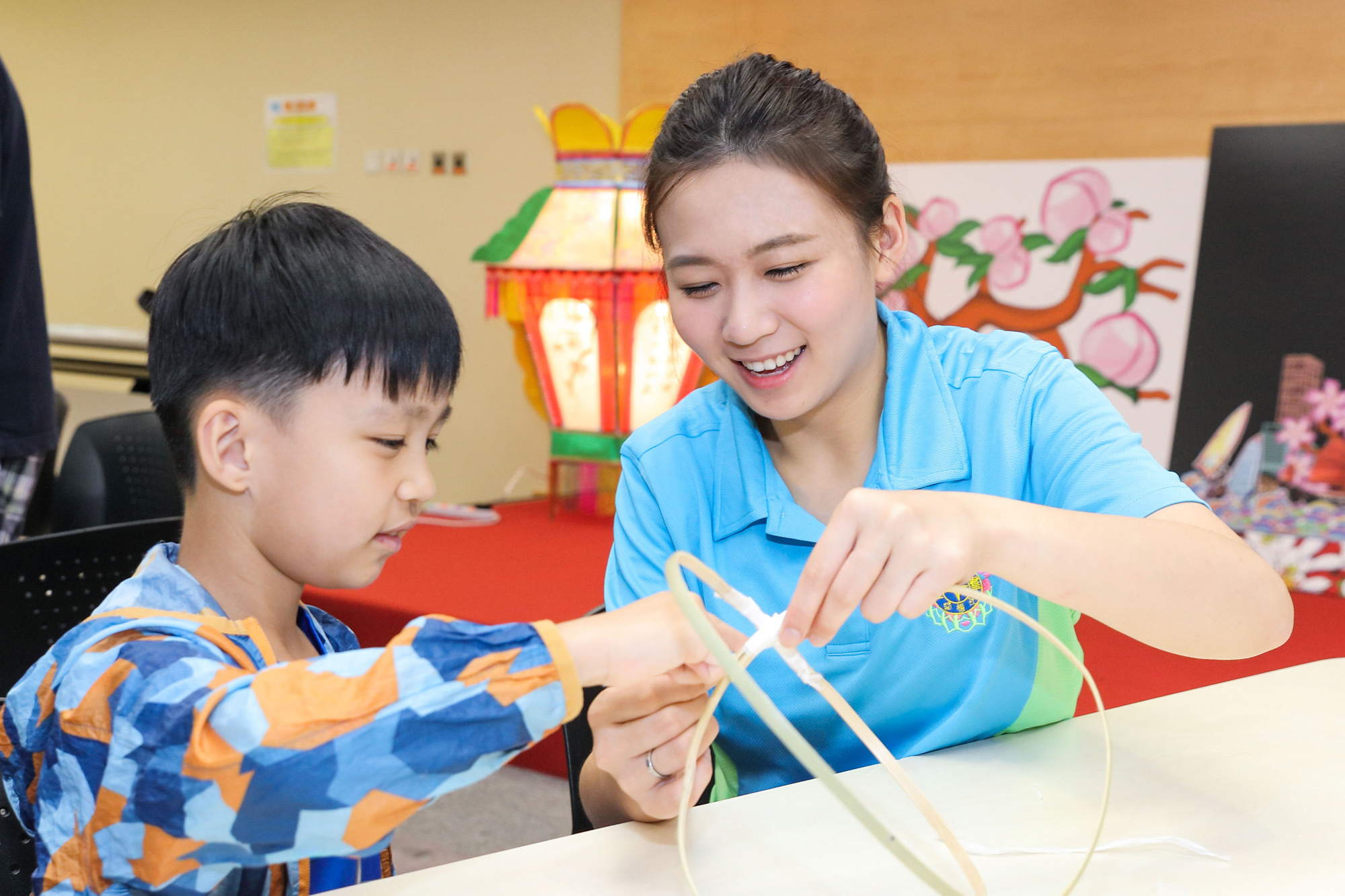 Volunteer of Oi Kwan Volunteer Group makes lantern with a patient of the Department of Paediatrics of Queen Mary Hospital.