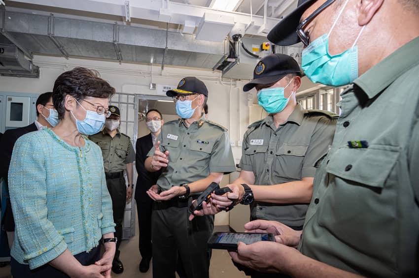 Officiating at the launching ceremony of the “Smart Prison” at Tai Tam Gap Correctional Institution, the then Chief Executive, Mrs Carrie Lam (first left), is briefed by correctional officers on the staff handheld device with data access and message delivery functions.