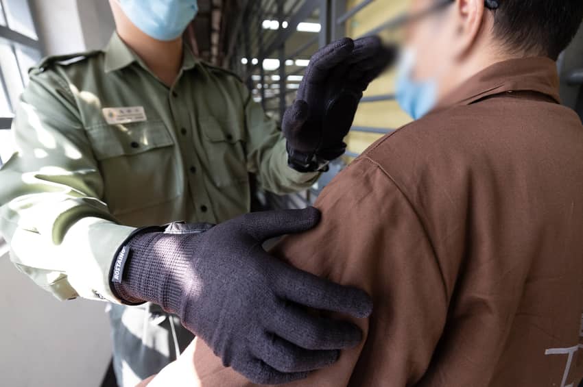 保安组搜查人员使用具防切割功能的金属探测手套进行搜查工作。