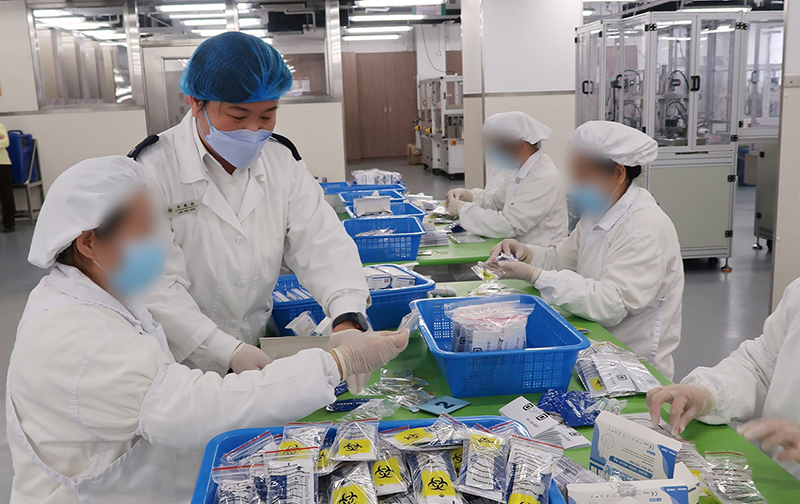 Persons in custody assist in the packaging of RAT kits at the Filter Mask Production Workshop of Lo Wu Correctional Institution.