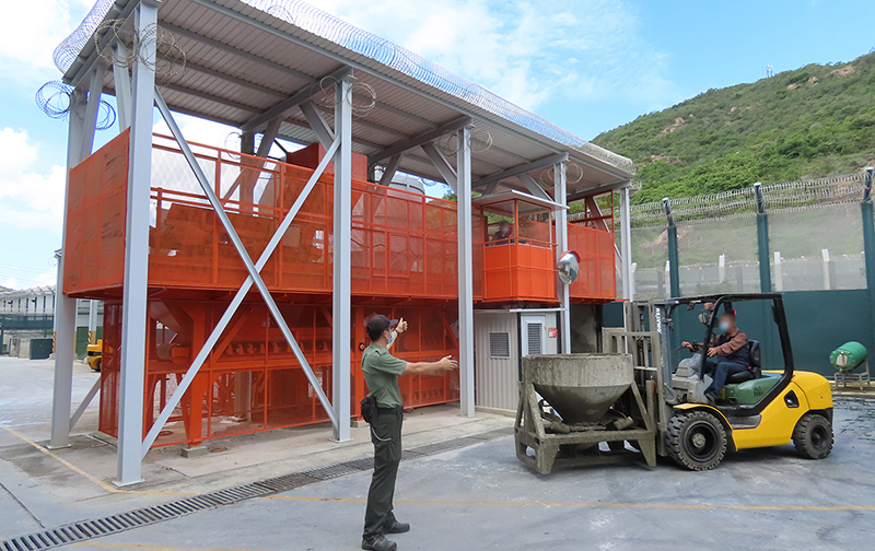 An Instructor teaches a person in custody about the operation of the computerised concrete batching and mixing system and the arrangement for transporting concrete products.