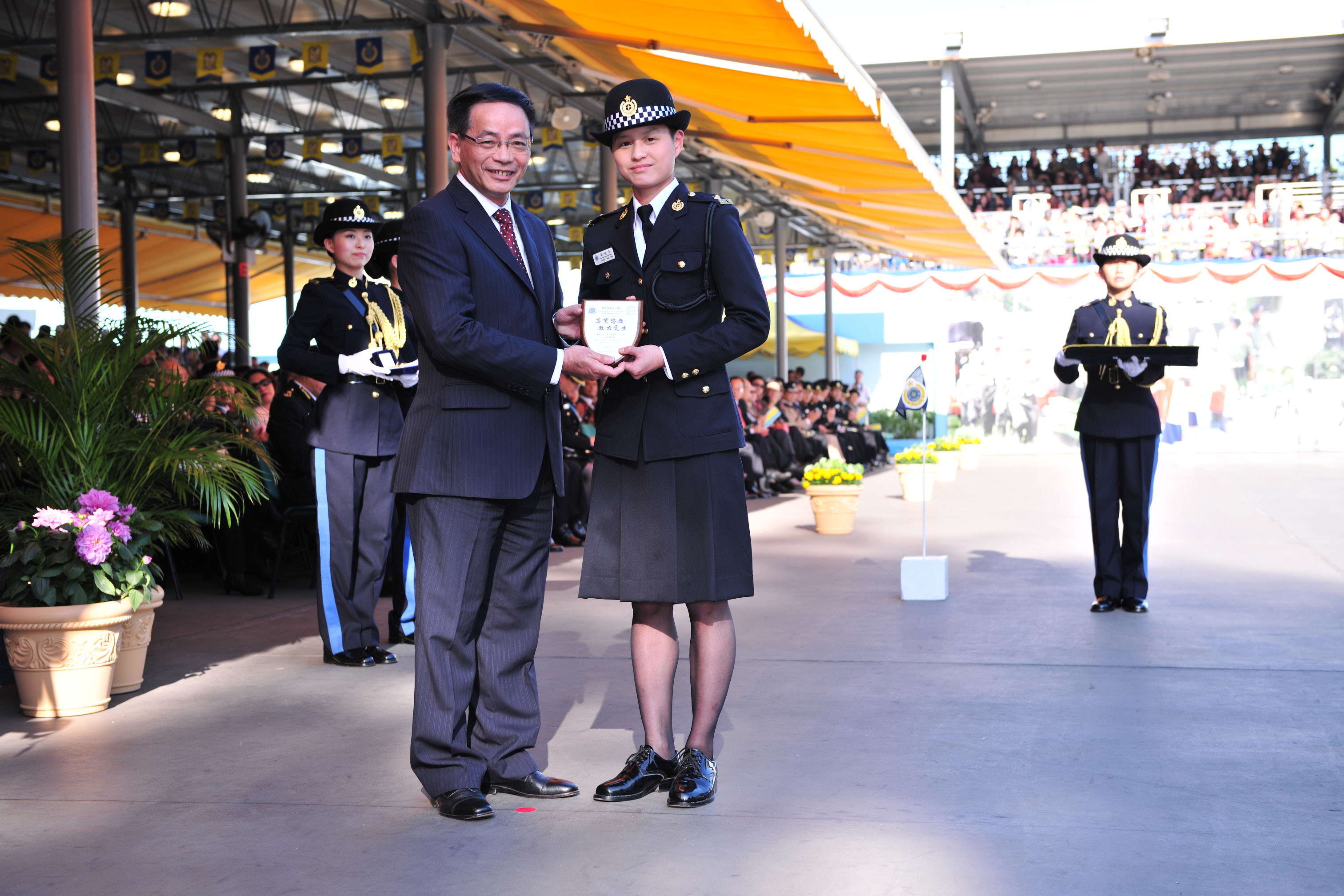 Mr Ip presents the Best Recruit Award, the Principal's Shield, to Officer Leung Hiu-yan.