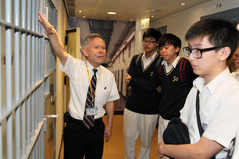 A tour guide of the museum introduces to visitors a mock cell at the museum.