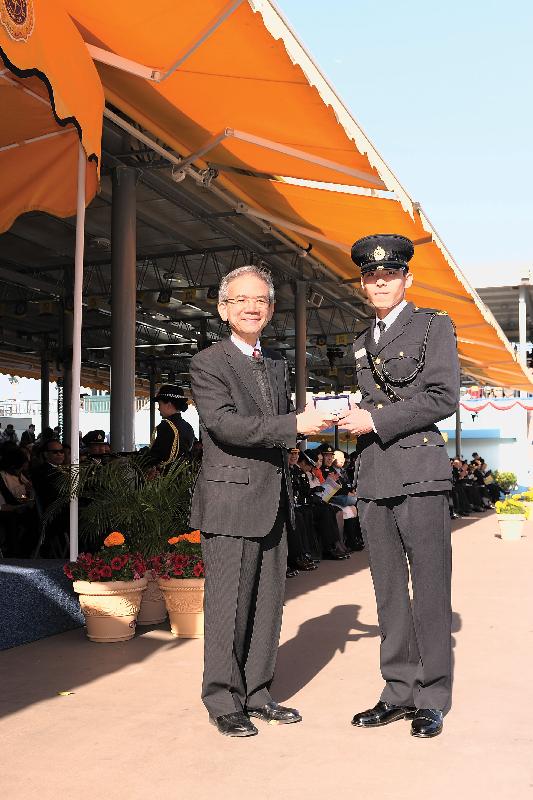 Mr Lam presents a Best Recruit Award, the Golden Whistle, to Assistant Officer II Man Chi-kin of Training Course No. 445.