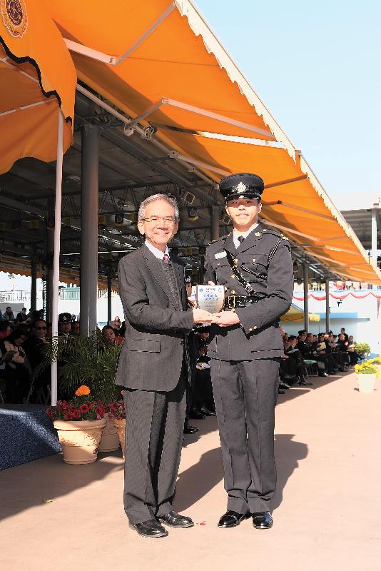 Mr Lam presents a Best Recruit Award, the Principal's Shield, to Officer Yan Ho-chun.  