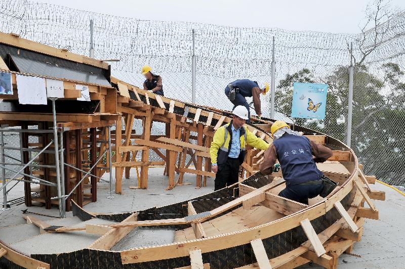 Persons in custody demonstrate the construction of a spiral staircase.