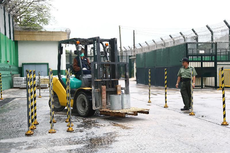 A person in custody demonstrates how to operate a forklift truck.