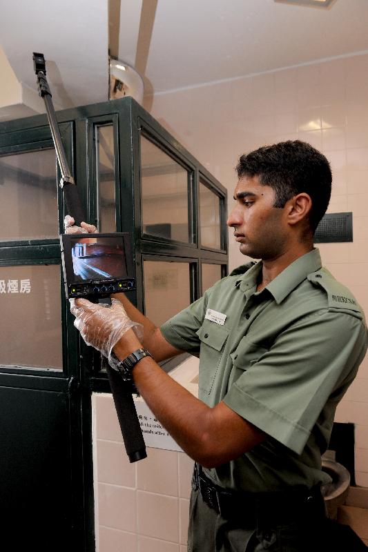 A correctional officer uses the extendable video pole camera system to search higher locations as he can view the areas concerned using the video camera without climbing up for the search.