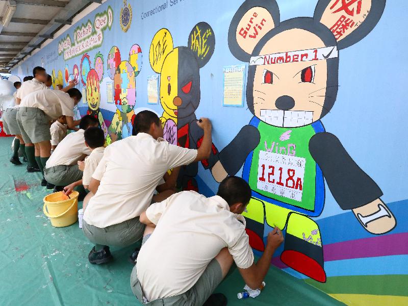 The Correctional Services Department and the Lions Club of Hong Kong (Pacific) held for the first time the "Rehab Qee" creative arts workshop and design competition at Cape Collinson Correctional Institution. Photo shows eight contestants adding the final touches to their paintings on a giant banner today (June 14) before submission.