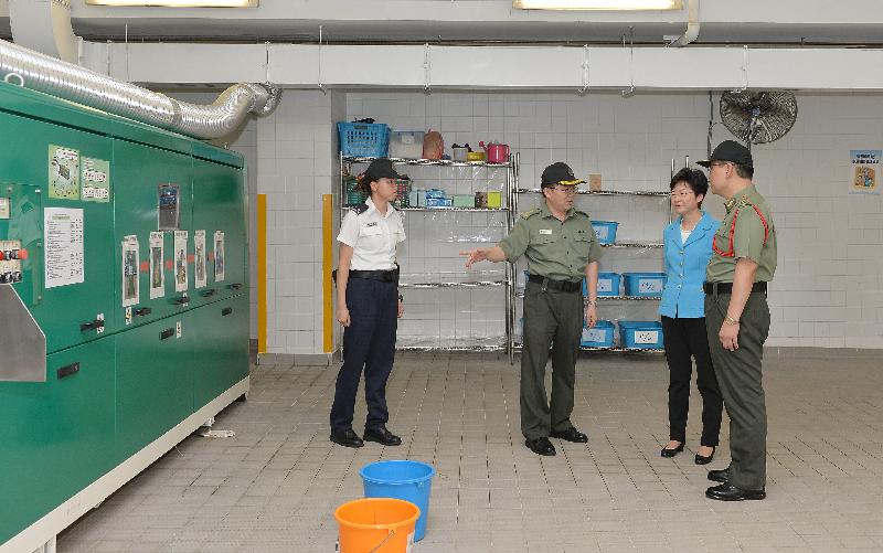 Mrs Lam (second right) is briefed on the food waste decomposing facilities and the "Waste No Food" Scheme launched by the institution.