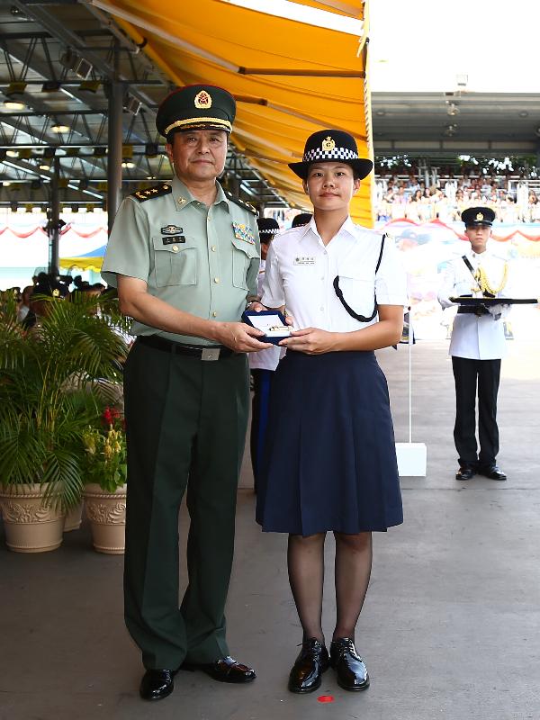 Mr Wang (left) presents the Best Recruit Award, the Golden Whistle, to Assistant Officer II Cheung Mui-kuen of Training Course No. 450.