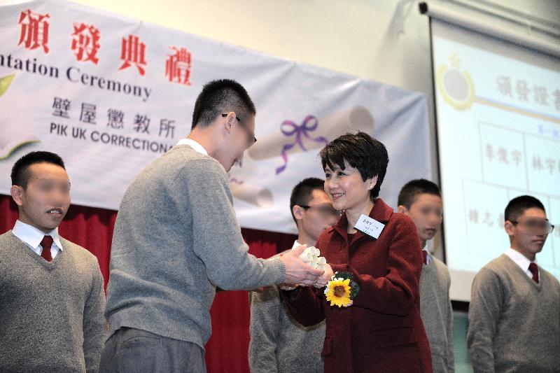 Thirty-nine young persons in custody at Pik Uk Correctional Institution of the Correctional Services Department were presented with certificates at a ceremony in recognition of their efforts and study achievements today (December 18). Photo shows the Chairman of Po Leung Kuk, Ms Angela Leong (right), presenting a certificate to a person in custody.