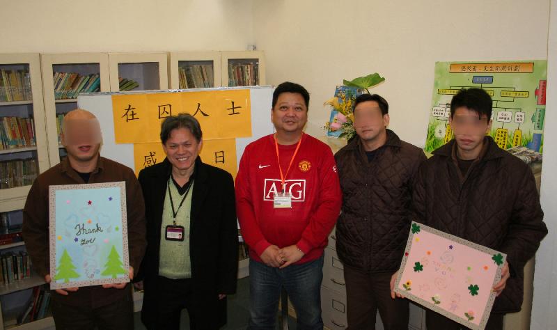 Persons in custody present souvenirs to NGOs and volunteers and join a group photo.