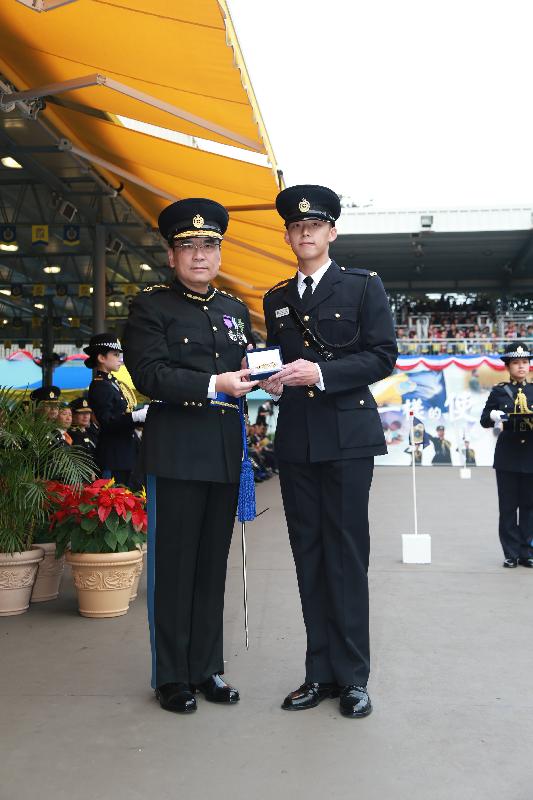 Mr Sin (left) presents the Best Recruit Award, the Golden Whistle, to Assistant Officer II Mr Cheung Man-ho at the passing-out parade.