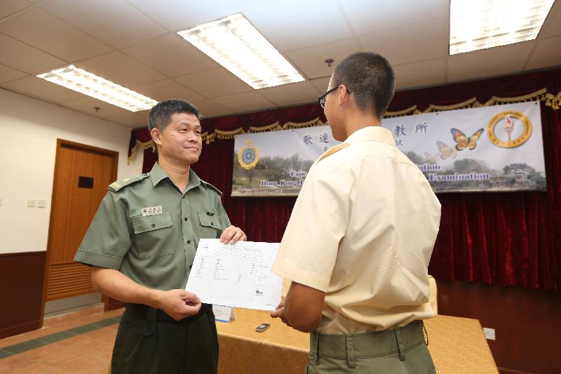 歌連臣角懲教所監督李兆佳（左）今日（七月十五日）頒發香港中學文憑考試成績通知書予青少年在囚人士。