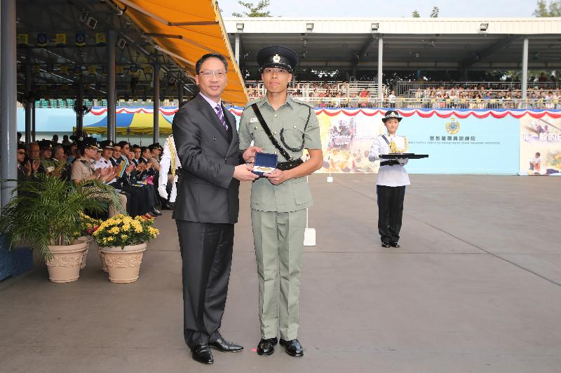 袁國強（左）頒發最優秀學員「金笛獎」予二級懲教助理鄭泳毅。