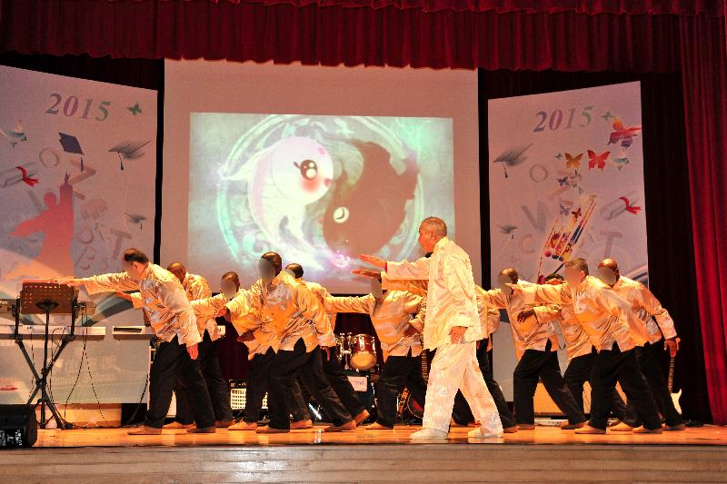 Persons in custody from international backgrounds stage a tai chi performance under the guidance of an instructor.