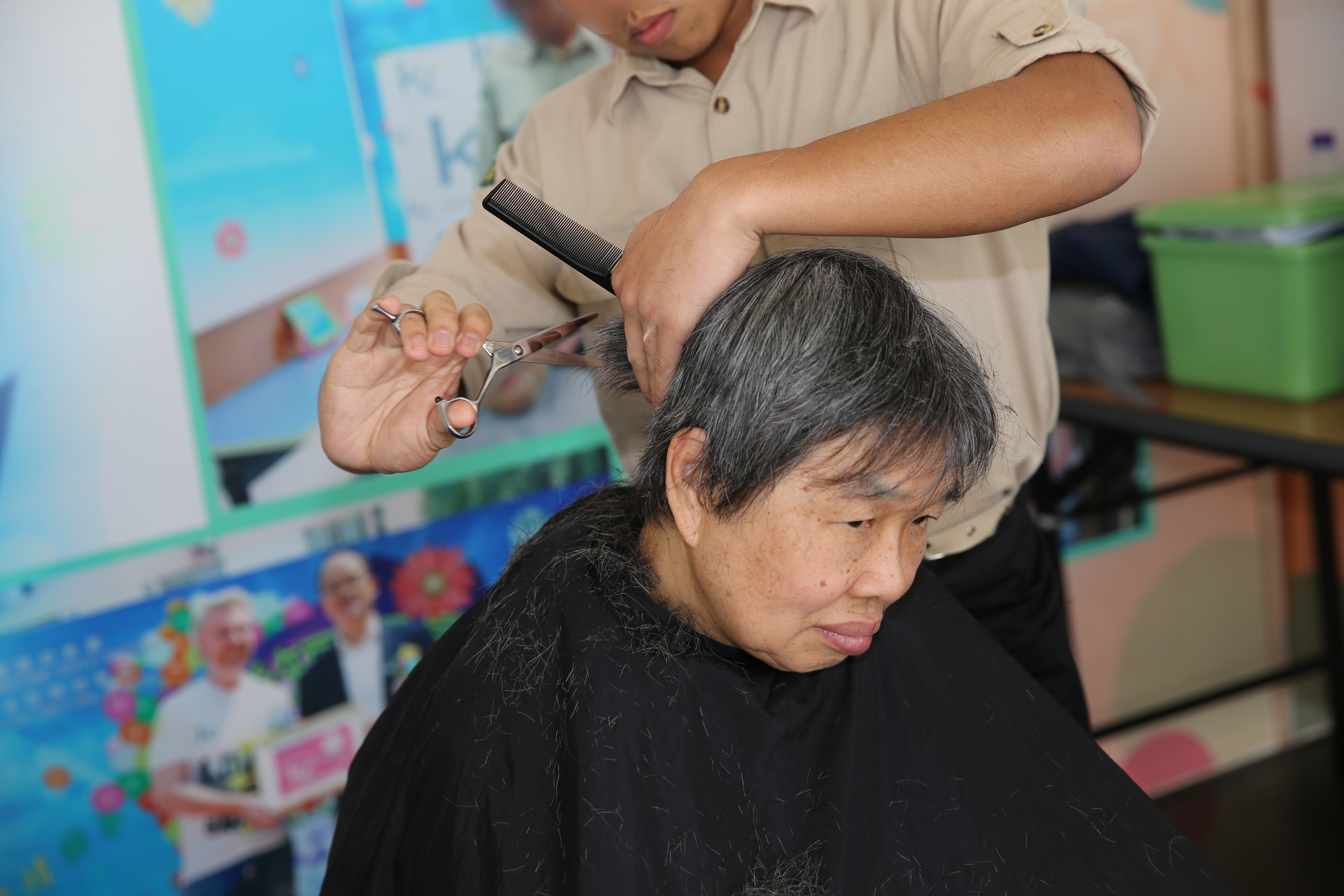 A person in custody of Cape Collinson Correctional Institution cut hair for an elderly visitor.