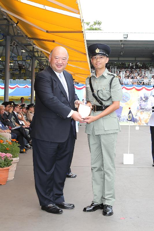 The Chief Justice of the Court of Final Appeal, Mr Geoffrey Ma Tao-li (left), presents a Best Recruit Award, the Principal's Shield, to Officer Chan Wing-hang at the Correctional Services Department (CSD) passing-out parade at the CSD's Staff Training Institute in Stanley today (June 17).