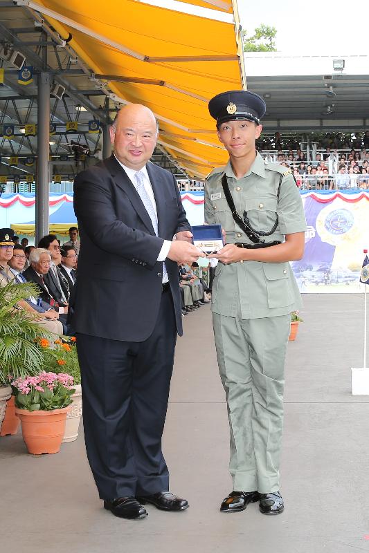 The Chief Justice of the Court of Final Appeal, Mr Geoffrey Ma Tao-li (left), presents a Best Recruit Award, the Golden Whistle, to Assistant Officer II Yu Lai-hong at the Correctional Services Department (CSD) passing-out parade at the CSD's Staff Training Institute in Stanley today (June 17).