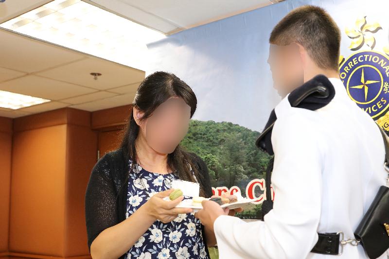 A person in custody thanks his mother for her unfailing love by giving her a homemade dessert during a certificate presentation ceremony at Cape Collinson Correctional Institution of the Correctional Services Department today (September 14). 