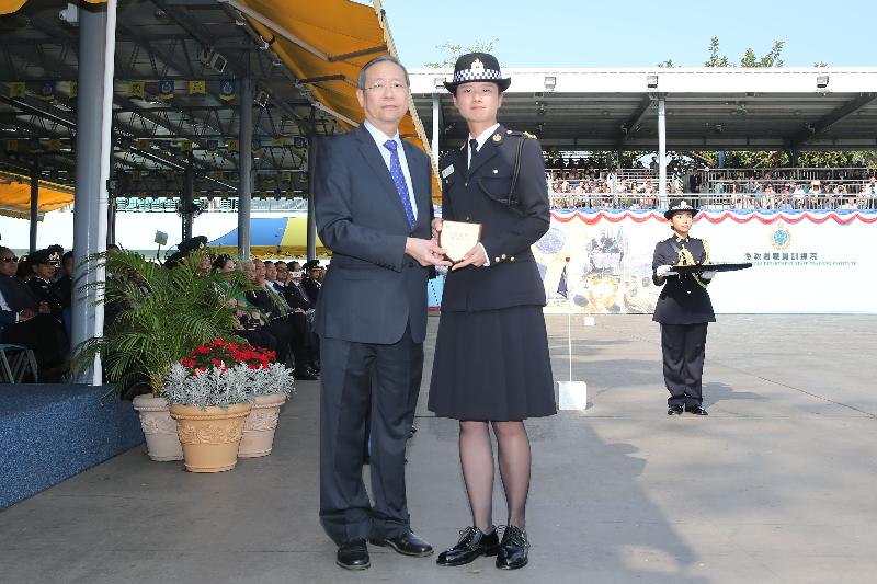 The Secretary for Security, Mr Lai Tung-kwok (left), presents a Best Recruit Award, the Principal's Shield, to Officer Miss Lam Nga-yee at the Correctional Services Department passing-out parade at its Staff Training Institute in Stanley today (April 28).