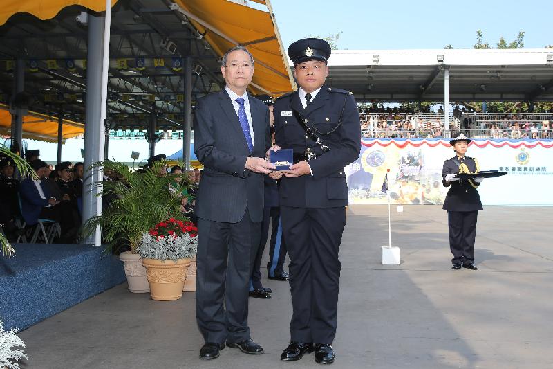 保安局局长黎栋国（左）今日（四月二十八日）于赤柱惩教署职员训练院学员结业会操上颁发最优秀学员「金笛奖」予二级惩教助理张桂业。