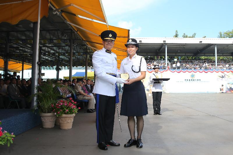 The Commissioner of Correctional Services, Mr Yau Chi-chiu (left), presents a Best Recruit Award, the Principal's Shield, to Officer Miss Tang Shuk-ching at the Passing-out cum Commissioner's Farewell Parade of the Correctional Services Department at its Staff Training Institute in Stanley today (August 18).