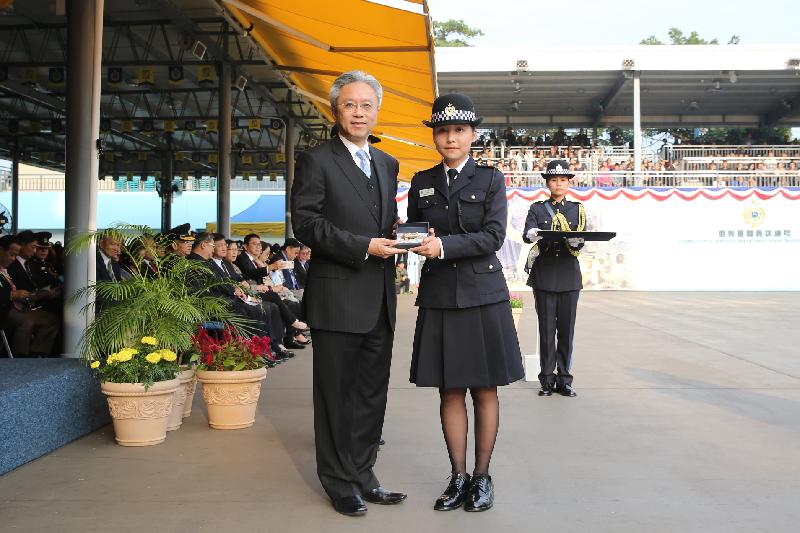 The Secretary for the Civil Service, Mr Joshua Law (left), presents a Best Recruit Award, the Golden Whistle, to Assistant Officer II Miss Kwok Sin-tung at the Correctional Services Department passing-out parade at its Staff Training Institute in Stanley today (December 7).