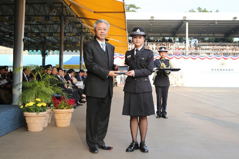 The Secretary for the Civil Service, Mr Joshua Law (left), presents a Best Recruit Award, the Golden Whistle, to Assistant Officer II Miss Chan Tak-yung at the Correctional Services Department passing-out parade at its Staff Training Institute in Stanley today (December 7).