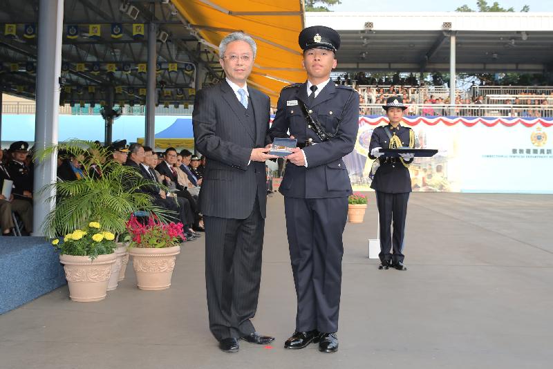 The Secretary for the Civil Service, Mr Joshua Law (left), presents a Best Recruit Award, the Golden Whistle, to Assistant Officer II Mr Kong Siu-pong at the Correctional Services Department passing-out parade at its Staff Training Institute in Stanley today (December 7).