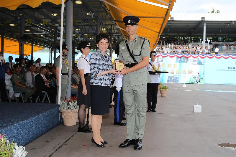 The Correctional Services Department held a passing-out parade at the Staff Training Institute in Stanley today (June 8). Photo shows the Chief Executive, Mrs Carrie Lam (left), presenting a Best Recruit Award, the Principal's Shield, to Officer Mr Siu Cheong-hung.