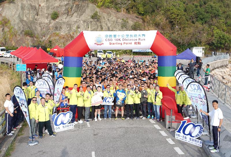 The Correctional Services Department held the 10km Distance Run at the Plover Cove Reservoir's main dam in Tai Po today (January 11). Photo shows the Commissioner of Correctional Services, Mr Woo Ying-ming, taking photos with athletes at the starting point before the event.