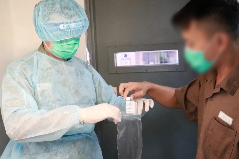 The Correctional Services Department arranged for persons in custody to undergo COVID-19 testing this week and announced today (September 11) that all testing results are negative. Photo shows a male person in custody returning the specimen bottle.