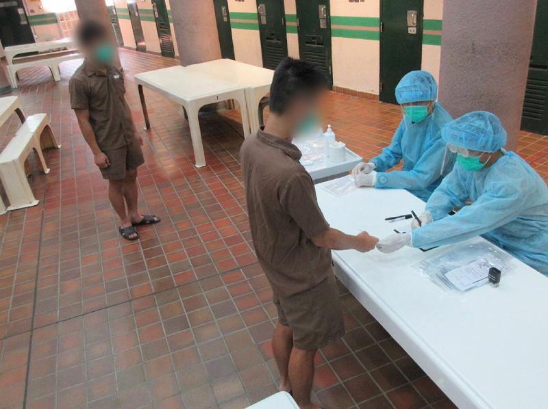 懲教署本星期為在囚人士進行2019冠狀病毒病測試，並於今日（九月十一日）公布結果全屬陰性。圖示懲教人員為男性在囚人士安排病毒測試。