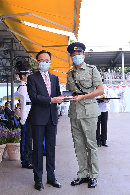 The Correctional Services Department held a passing-out parade at the Staff Training Institute in Stanley today (June 11). Photo shows the Secretary for the Civil Service, Mr Patrick Nip (left), presenting a Best Recruit Award, the Golden Whistle, to Assistant Officer II Mr Cheng Ho-nam.