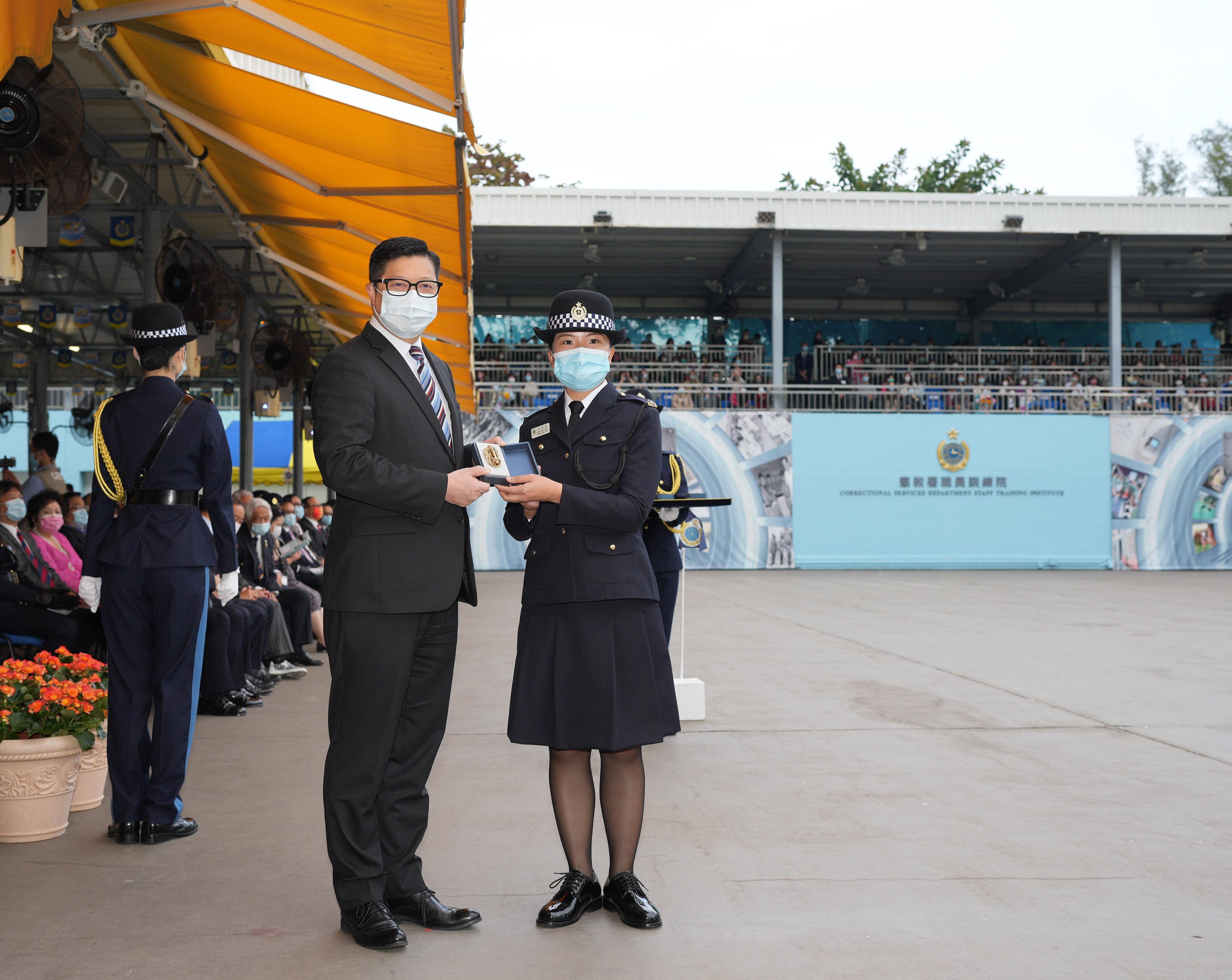 The Correctional Services Department held a passing-out parade at the Staff Training Institute in Stanley today (December 17). Photo shows the Secretary for Security, Mr Tang Ping-keung (left), presenting a Best Recruit Award, the Golden Whistle, to Assistant Officer II Ms Wong Ka-po.