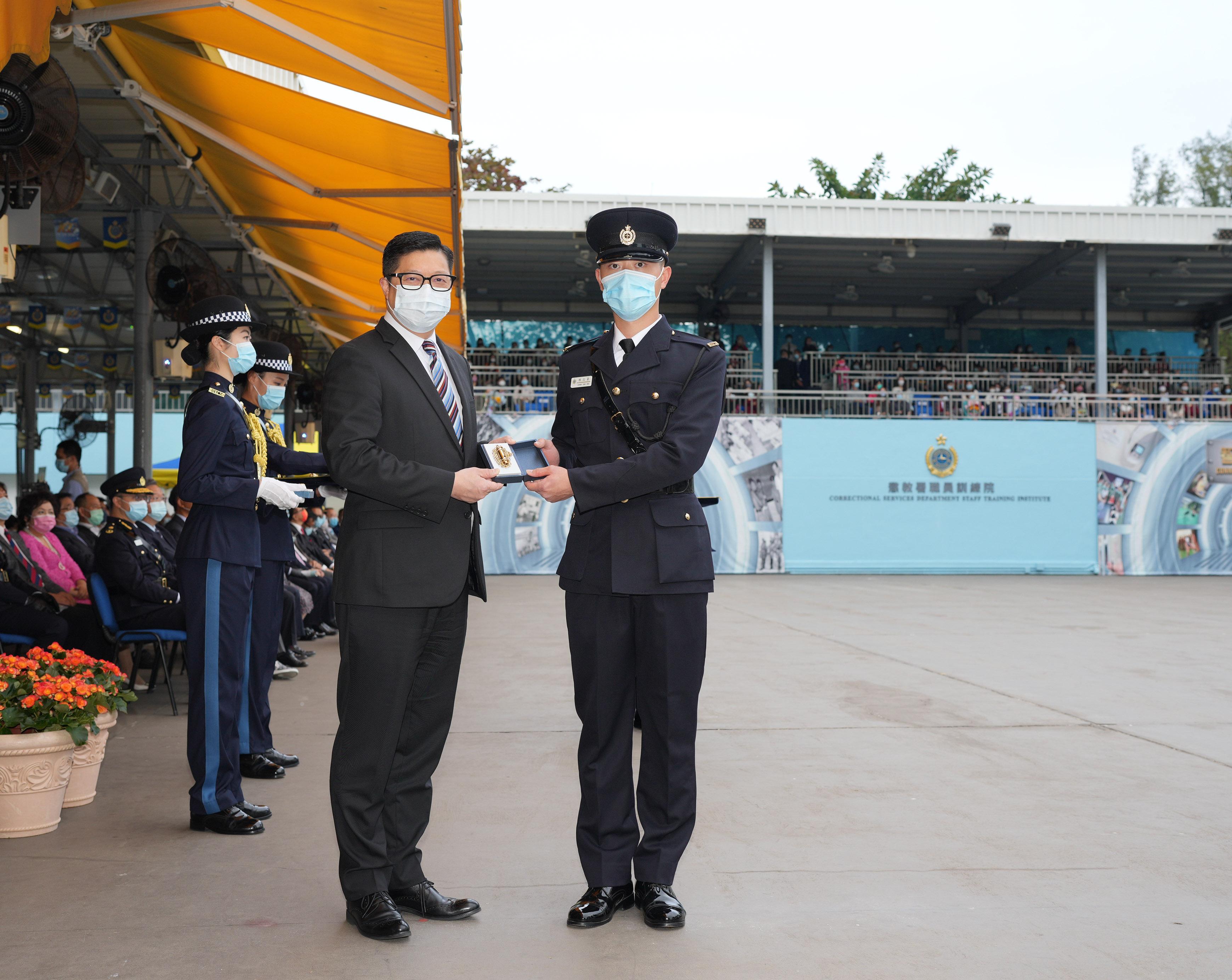 The Correctional Services Department held a passing-out parade at the Staff Training Institute in Stanley today (December 17). Photo shows the Secretary for Security, Mr Tang Ping-keung (left), presenting a Best Recruit Award, the Golden Whistle, to Assistant Officer II Mr Chen Chi-ho.